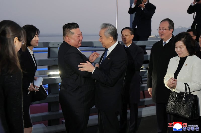 2026년 10월 24일 중국 랴오닝성 단둥의 압록강 북중 국경 다리에서 김정은 북한 국무위원장이 왕이 중국 외교부장과 작별 인사를 나누고 있다.