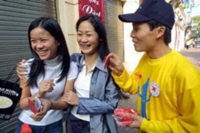 Tình nguyện viên chương trình phòng chống HIV/AIDS đang phân phát condom trên đường phố Hà Nội. AFP PHOTO