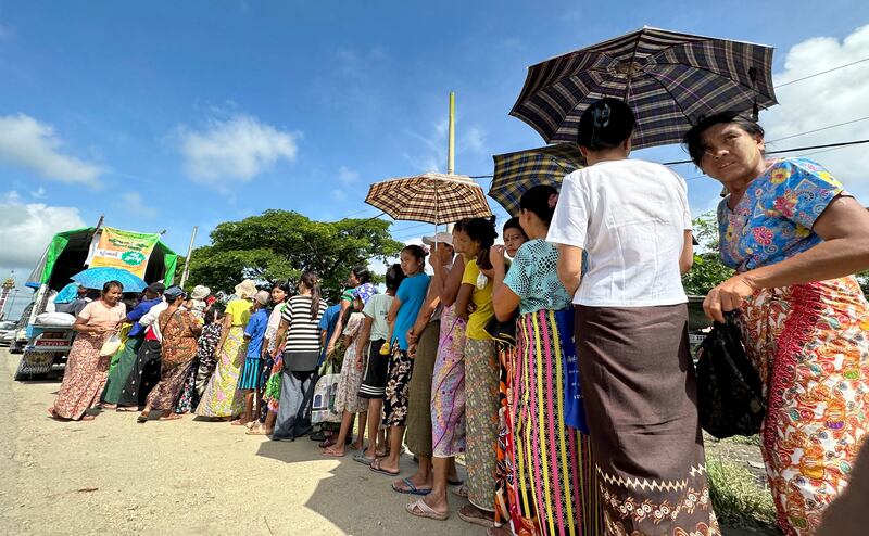ရန်ကုန်တိုင်း ဒလမြို့နယ် ဒလ-တွံ့တေးလမ်းပေါ်မှာ ဆန်တစ်ပြည်ကို ၂၅၀၀ ကျပ်နှုန်းနှင့် ရောင်းပေးနေသည့်နေရာမှာ တန်းစီဝယ်ယူနေကြသည့် မြို့ခံများအား ၂၀၂၃ ခုနှစ် စက်တင်ဘာလ ၂၂ ရက်နေ့က မြင့်တွေ့ရစဉ်။ Photo : RFA