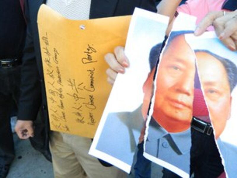 图片:示威群众将破碎的毛像置入大信封,丢向中领馆大门。 (记者萧融拍摄)