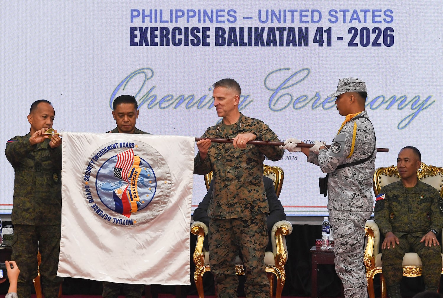 (From left to right) Major General Francisco Lorenzo, Philippine exercise director, and military Chief General Romeo Brawner of the Philippines, with U.S. Lieutenant General Christian Wortman, unfurling a banner during the opening ceremony of the annual 