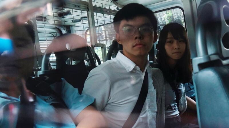 2019年8月30日,香港众志秘书长黄之锋(左)和成员周庭(右)早上被捕,下午由警车押往东区法院提堂。(路透社)