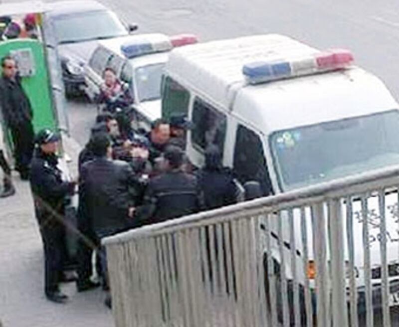 非京籍學生家長3月28日到北京巿教委請願時,數名警察將一名男家長強行拉上警車。(照片由家長提供)