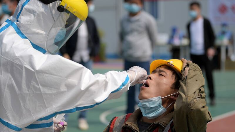 图为,2020年4月7日,湖北省武汉市的一名建筑工人在进行核酸测试。(路透社)