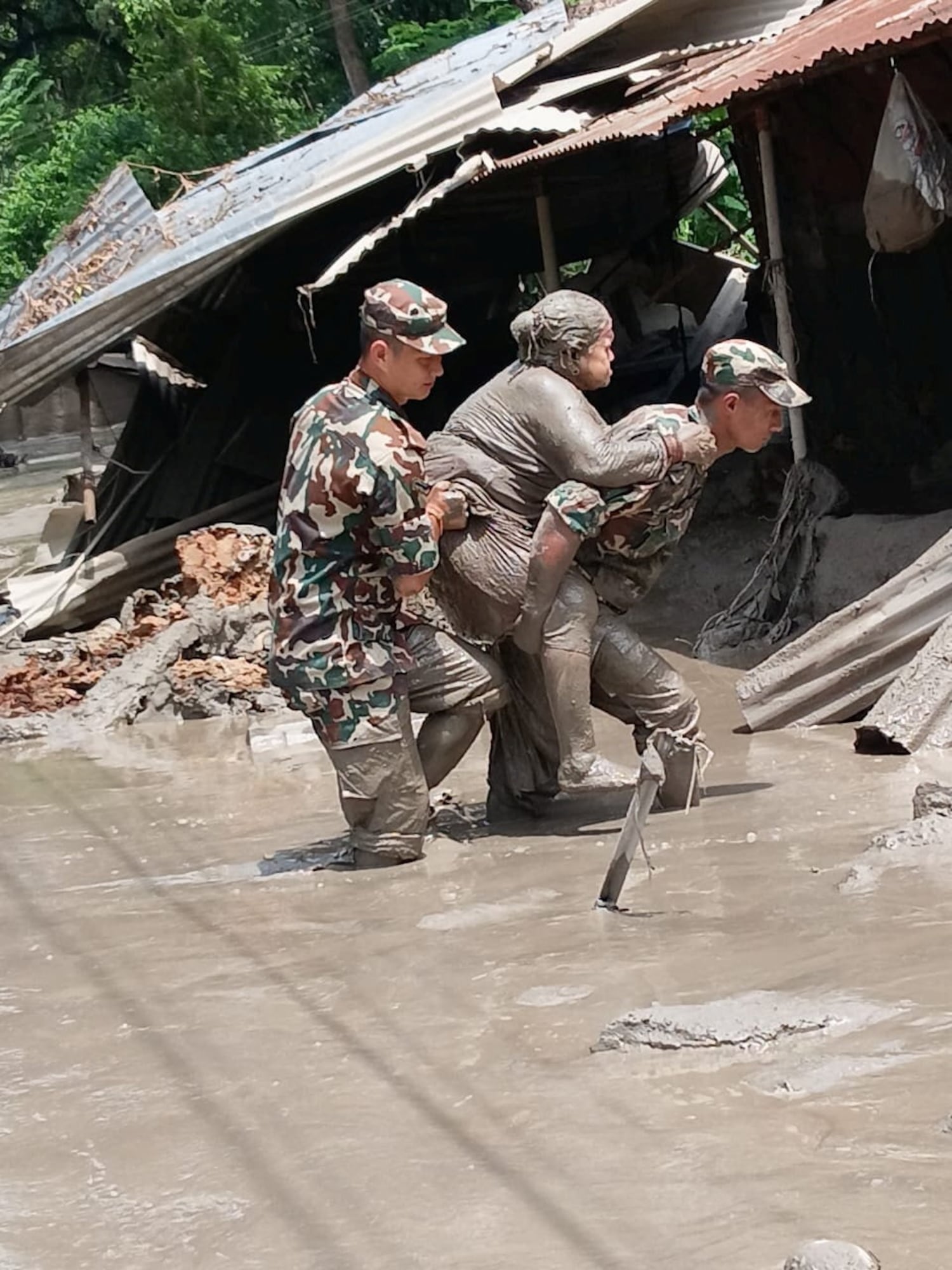 Nepali army soldiers move a survivor following flash floods and a mudslide near the Nepal-Tibet border in Nepal, Aug. 27, 2026.