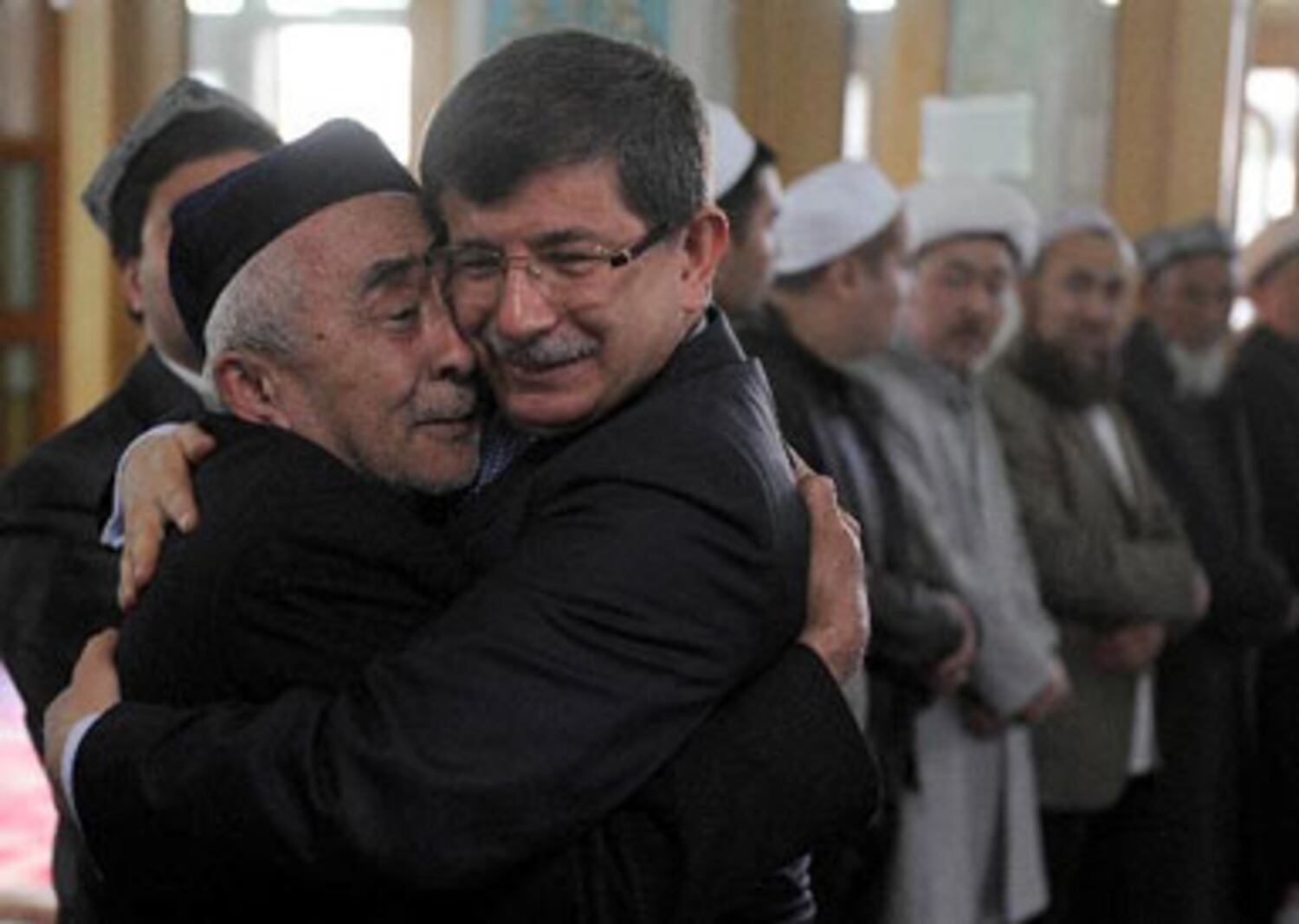 ئۇيغۇر بوۋاينىڭ تۈركىيە تاشقى ئىشلار مىنىستىرى ئەخمەت داۋۇتئوغلى بىلەن كۆز ياشلىرى ئىچىدە يۈز يېقىشىپ تۇرغان كۆرۈنۈش. 2012-يىلى 8-ئاپرېل، ئۈرۈمچى.