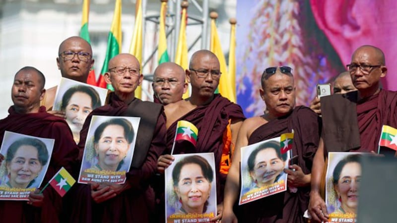 Buddhist monks hold portraits of Myanmar leader Aung San Suu Kyi while standing on a stage to pray during a rally in front of City Hall in Myanmar's commercial capital Yangon, Dec. 10, 2019. 