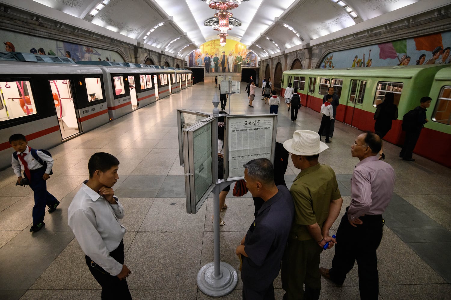 Commuters read a newspaper in a subway station in Pyongyang on June 19, 2019.