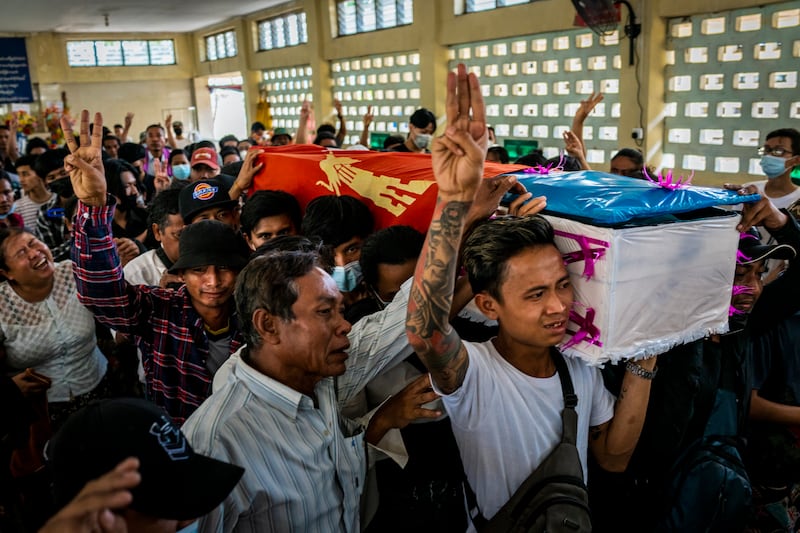 Mourners make three-fingered salutes while carrying a coffin during the funeral of Aung Kaung Htet, 15, who was killed when military junta forces opened fire on anti-coup protesters, on March 21, 2021 in Yangon, Myanmar.