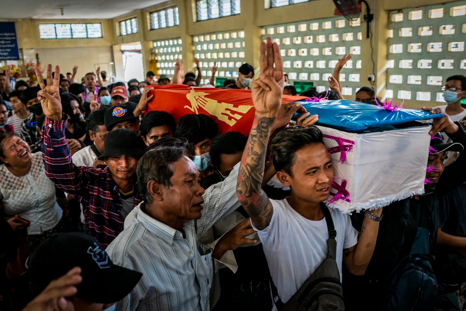 Mourners make three-fingered salutes while carrying a coffin during the funeral of Aung Kaung Htet, 15, who was killed when military junta forces opened fire on anti-coup protesters, on March 21, 2021 in Yangon, Myanmar.