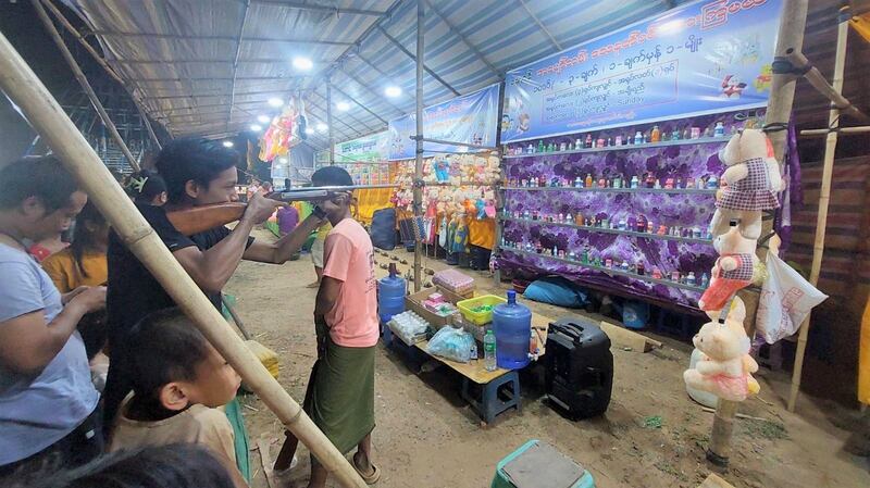 မန္တလေးတိုင်း ညောင်ဦးမြို့ ရွှေစည်းခုံဘုရားအနီးတွင် ရောင်းချနေသည့် ဆယ့်နှစ်ပွဲစျေးသည်များနှင့် ပွဲဈေးလာသူများကို ၂၀၂၃ ခုနှစ် ဇွန်လ ၁ ရက်နေ့ညက တွေ့ရစဉ်။ (Photo: RFA)