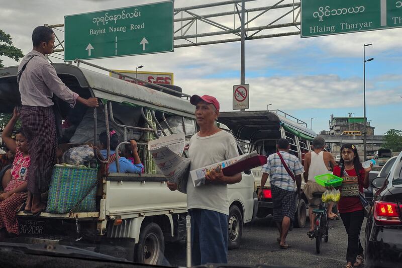 ဘုရင့်နောင်လမ်းဆုံမှာ သတင်းစာ လက်ပွေ့ရောင်းချနေသူတစ်ဦးကို ၂၀၂၃ ခုနှစ် စက်တင်ဘာလ ၇ ရက်နေ့က တွေ့ရစဉ်။ (Photo: RFA)