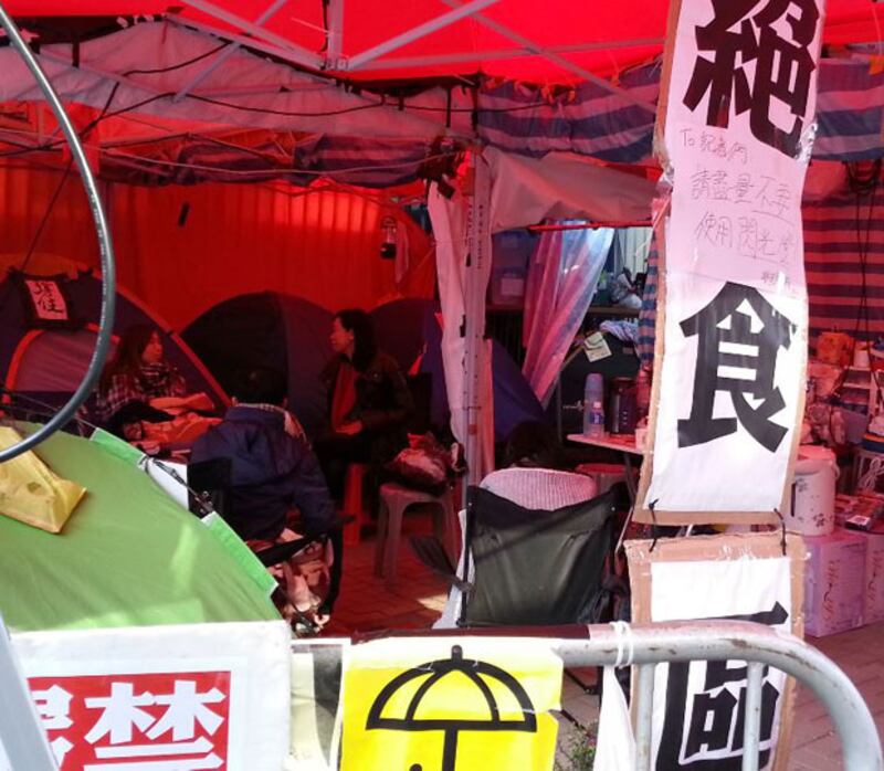 2014年12月8日，繼續絕食的“學民思潮”成員在金鐘絶食區內休息。（粵語部林靜攝）