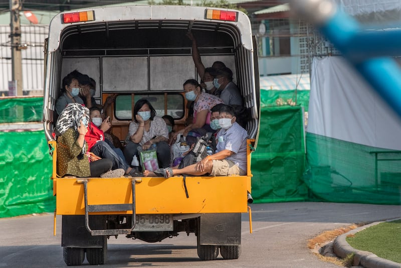 Migrant workers and their families ride in the back of a truck in Samut Sakhon, Thailand, Jan. 4, 2021.