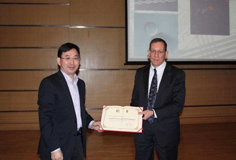 2014年,利伯(右)訪問中國科學院化學研究所並獲「分子科學前沿講座教授」聘書。(中國科學院化學分院官網)