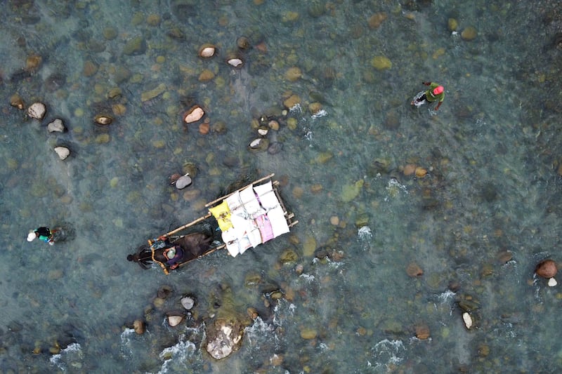 Residents cross the Bangot River, a vital source of livelihood for the indigenous Aeta near Capas, Tarlac, Philippines, Sept. 15, 2026