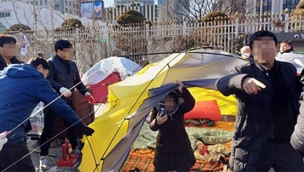 15일 오후 정부서울청사 앞에서 종로구청 관계자들이 탈북민 단체가 불법으로 설치한 텐트를 철거하자 탈북민 등으로 구성된 이 단체 관계자들이 항의하고 있다.