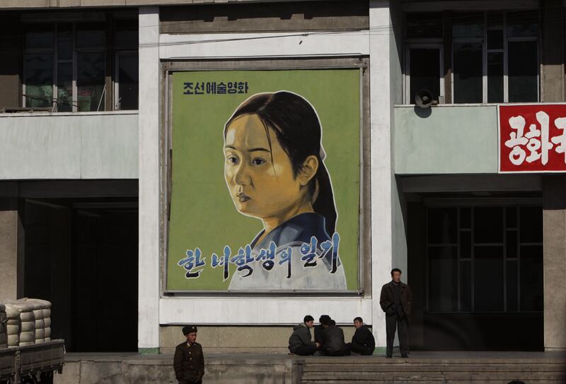 2008-02-27T120000Z_200777008_GM1E42R1GA001_RTRMADP_3_KOREA-NORTH A North Korean soldier stands in front of a painting of a North Korean movie actor at a local movie theatre in the capital of Pyongyang 02272008.JPG
