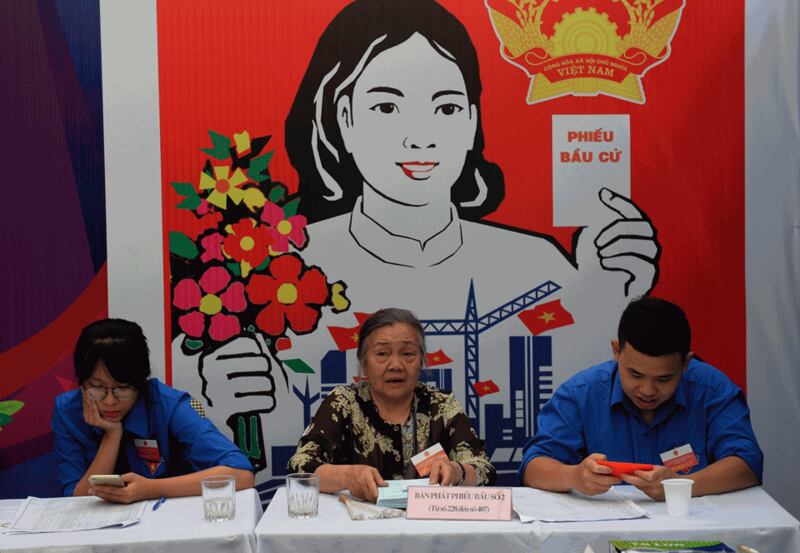 Hình minh họa. Hai đoàn viên Đoàn Thanh niên Cộng sản và một phụ nữ lớn tuổi tại một bàn phát phiếu bầu cử ở Hà Nội hôm 22/5/2016