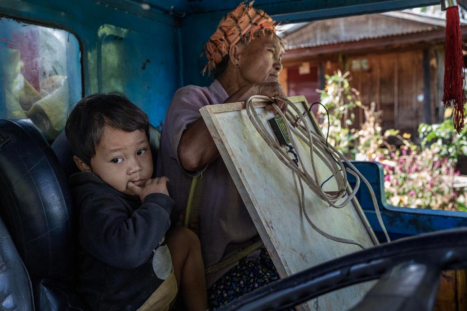 A woman holds a solar panel as her family prepares to flee Phuk Khe village in southern Shan state, Myanmar, Oct. 30, 2024.
