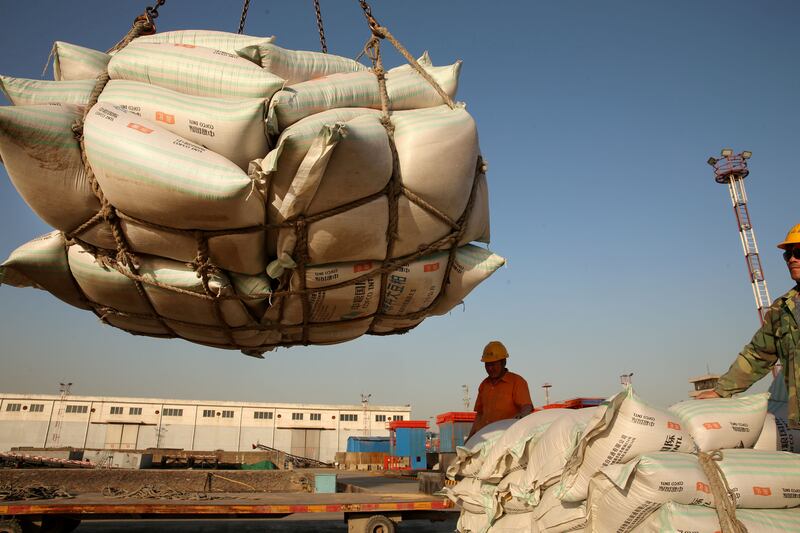 Workers transport imported soybean products at a port in Nantong, Jiangsu province, China, April 9, 2018.