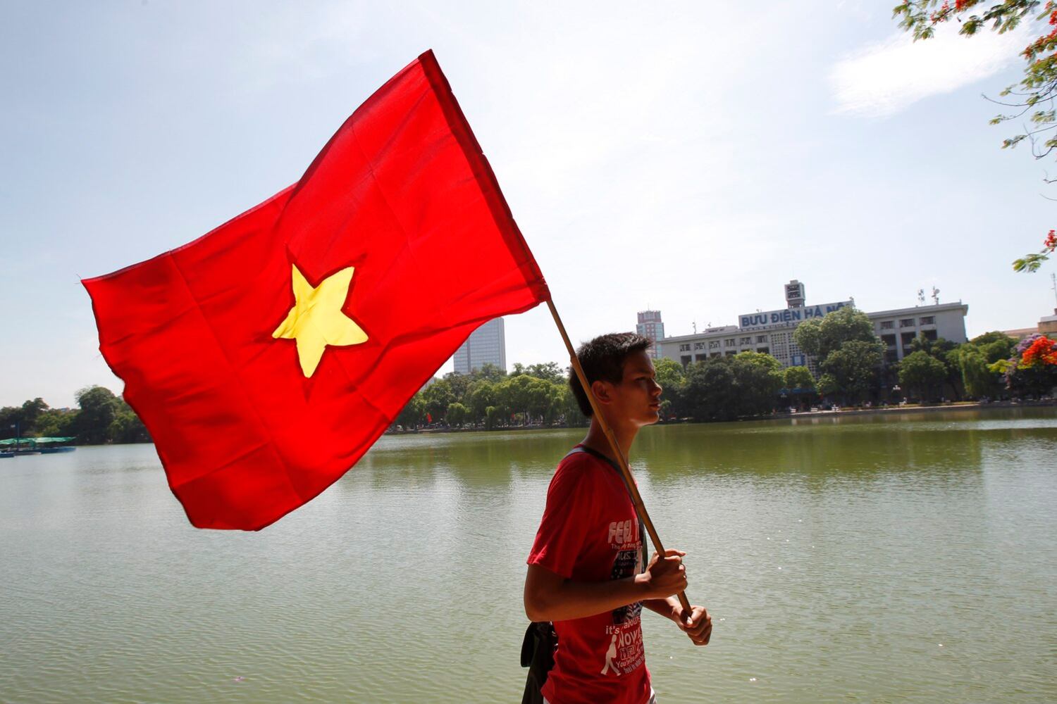 Một người biểu thình phản đối Trung Quốc  mang cờ Việt Nam đi dọc bờ Hồ Hoàn Kiếm hôm 5/6/2011 (minh họa)