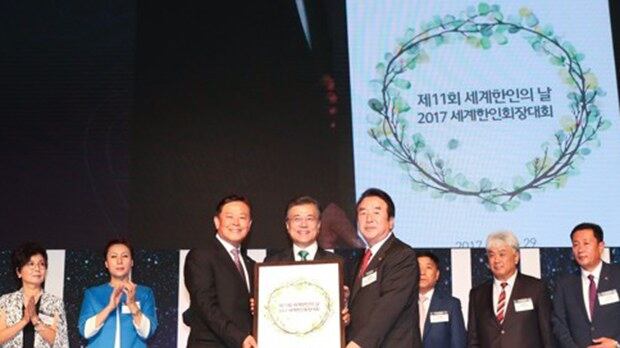 서울 송파구 롯데호텔월드에서 열린 '제11회 세계한인의 날 기념식 및 2017 세계한인회장대회 개회식'에 참석한 문재인 대통령에게 남창규.오공태 세계한인회장들이 지장을 찍어 만든 평화의 월계관 액자를 전달하고 있다.