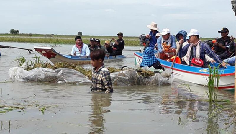 អាជ្ញាធរ​ខេត្ត​បាត់ដំបង​ដែល​ជាប់​ខេត្ត​បន្ទាយមានជ័យ ជួប​កសិករ​ច្រូត​ស្រូវ​លិច​ទឹក​នៅ​​ក្នុង​ឃុំ​ព្រែកហ្លួង ស្រុក​ឯក​ភ្នំ ខេត្ត​បាត់ដំបង ដែល​កំពុង​លិចលង់​ដោយ​ទឹក​ជំនន់ ថ្ងៃ​ទី​៣ ខែ​សីហា ឆ្នាំ ២០១៨។ 
