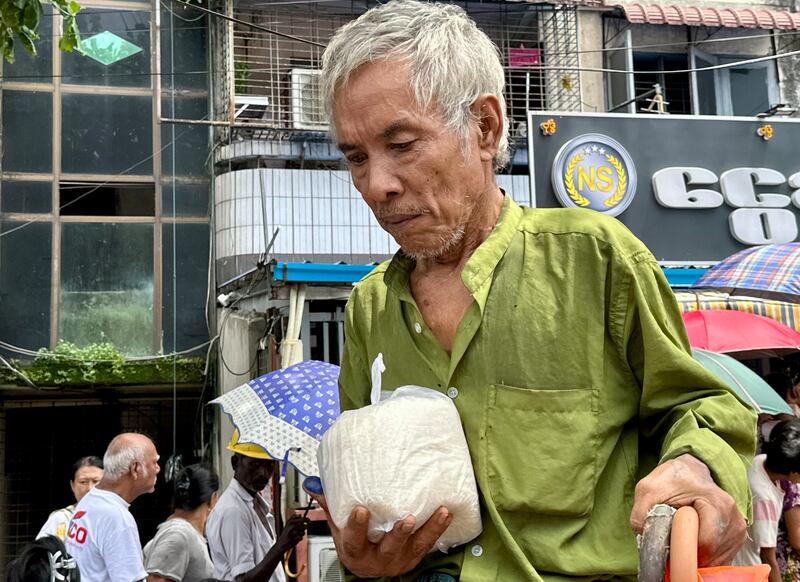 ၂၀၂၃ ခုနှစ် သြဂုတ်လ ၂၇ ရက်နေ့က ရန်ကုန်တိုင်း သင်္ဃန်းကျွန်းမြို့နယ် လေးထောင့်ကန်လမ်းမပေါ်မှာ ဆန်နဲ့ ကြက်ဥ ဈေးလျှော့ရောင်းတာကို လာရောက်ဝယ်ယူသူတစ်ဦးကို တွေ့ရစဉ်။