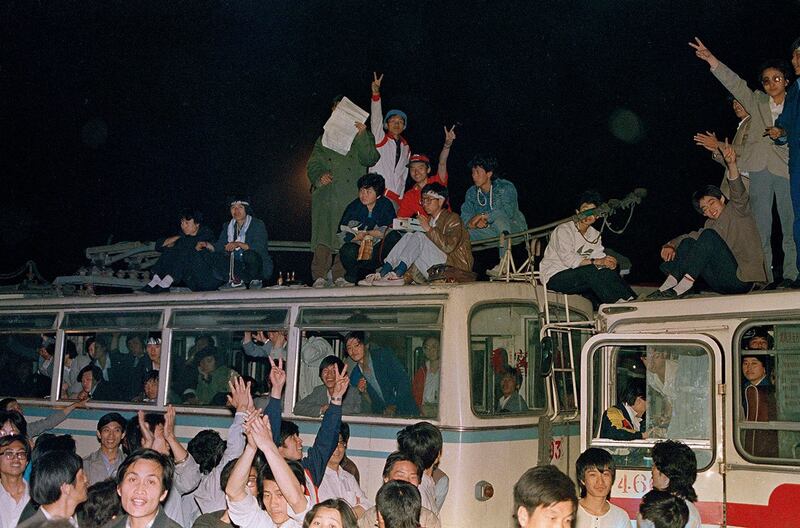 1989年5月22日凌晨，北京，学生在用于阻挡军队行动的公交车上打着胜利手势。（美联社）