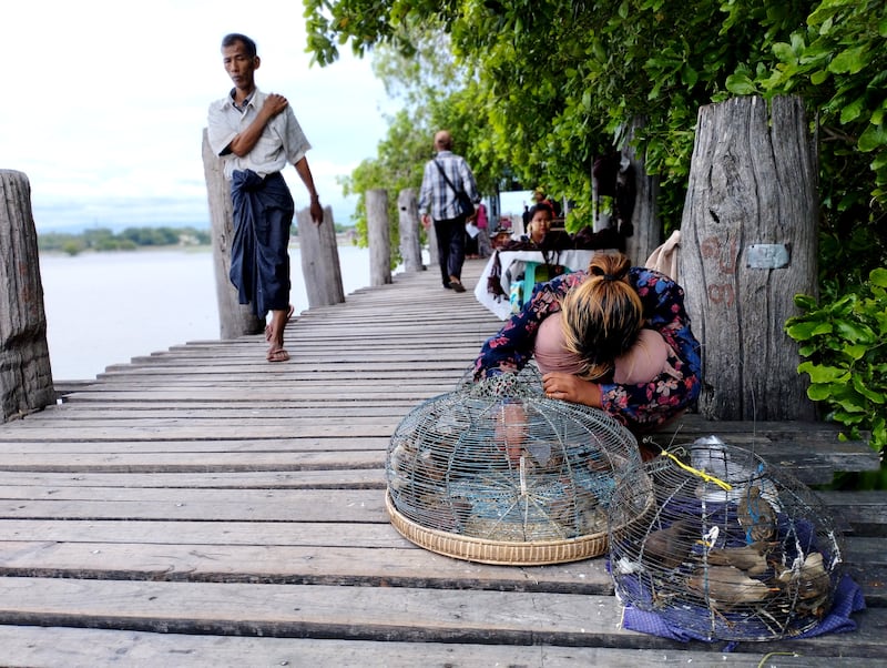 မန္တလေးတိုင်း အမရပူရမြို့နယ်မှ ဦးပိန်တံတားတွင် ဈေးသည်တချို့အား ၂၀၂၃ ခုနှစ် ဇူလိုင်လ ၁၂ ရက်နေ့က တွေ့ရစဉ်။ (Photo: RFA)