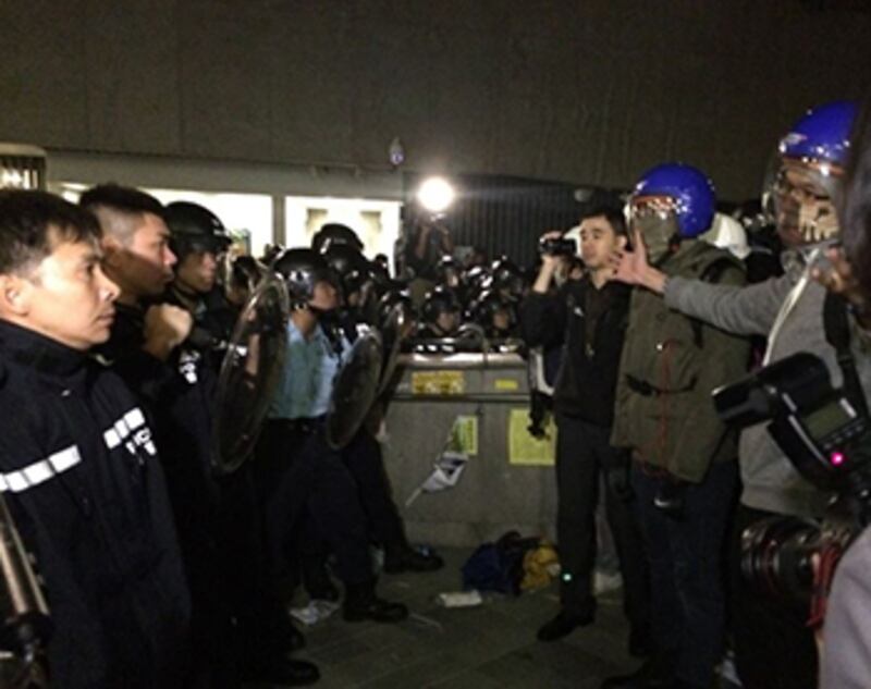 2014年11月19日凌晨，大批手持盾牌、警棍的警員趕到立法會衝擊現場，示威者排成人鏈與警方對峙。(現場人士攝)
