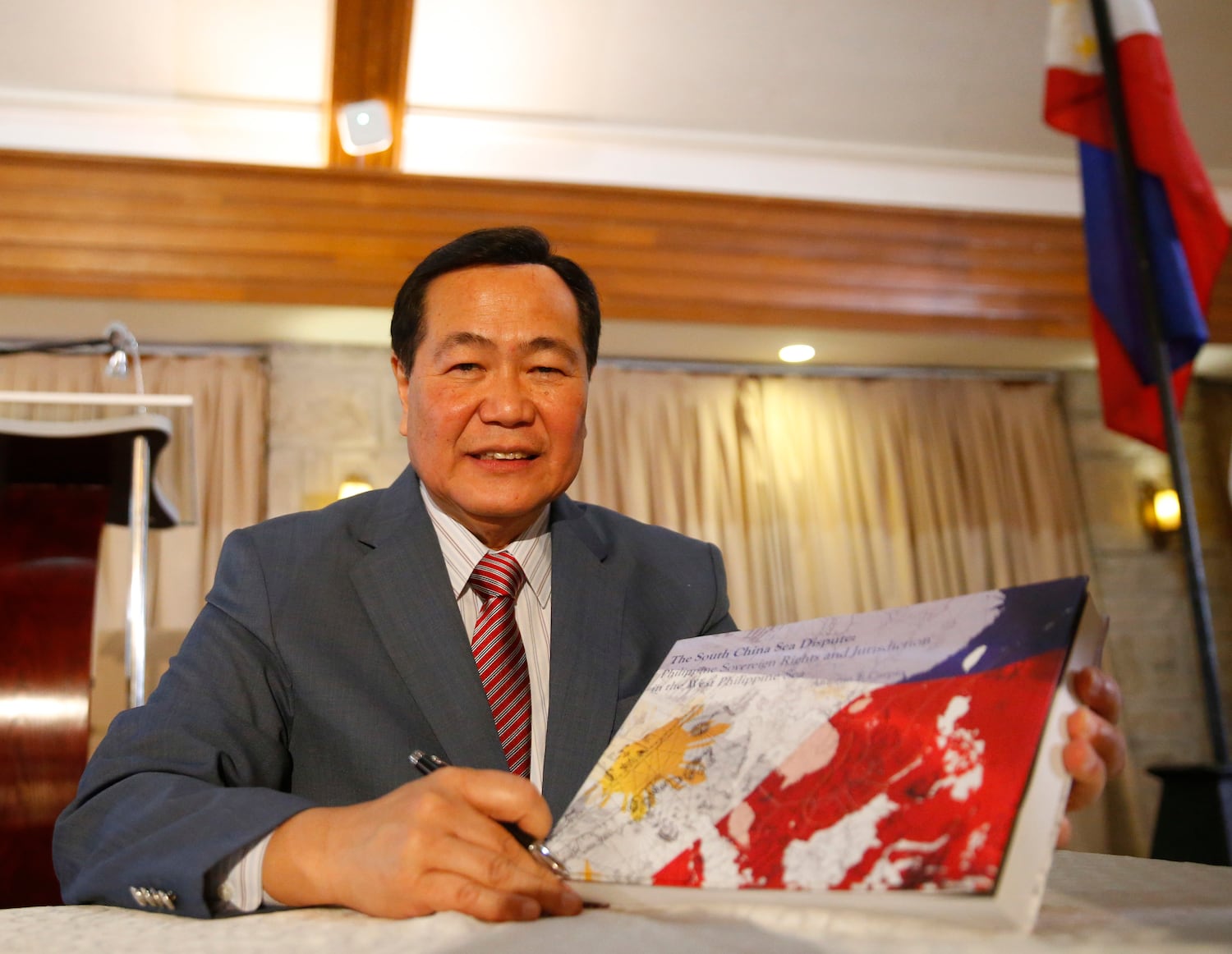 Philippine Supreme Court Senior Associate Justice Antonio Carpio holds a hard copy of his e-book