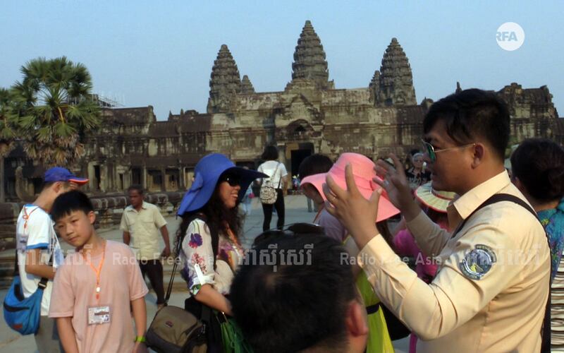 មគ្គុទ្ទេសក៍​ទេសចរ​និយាយ​ភាសា​ចិន (ស្ដាំ) នាំ​ភ្ញៀវ​ទេសចរ​ចិន ទៅ​មើល​ប្រាសាទ​អង្គរវត្ត ខេត្ត​សៀមរាប កាល​ពី​ថ្ងៃ​ទី​១៨ ខែ​កក្កដា ឆ្នាំ​២០១៧។ 