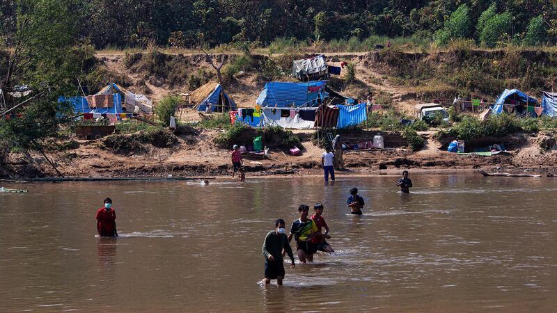 တိုက်ပွဲတွေကြောင့် သံလွင်မြစ်ကိုဖြတ်ကူးပြီး ထိုင်းနိုင်ငံနယ်စပ်သို့ ထွက်ပြေးတိမ်းရှောင်လာကြသည့် မြန်မာနိုင်ငံဘက်မှ စစ်ဘေးဒုက္ခသည်များအား ၂၀၂၂ ခုနှစ်၊ ဇန်နဝါရီ ၁၅ ရက်နေ့က တွေ့ရစဉ်။ (Photo: AFP)