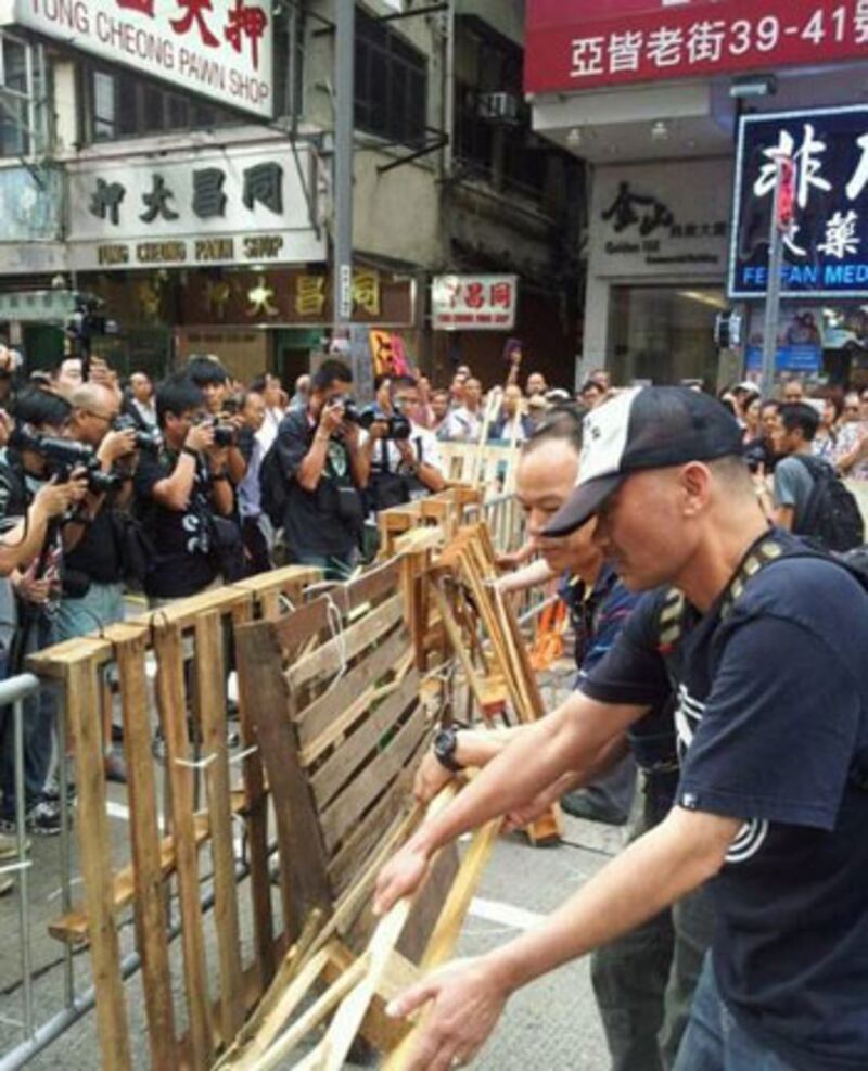 2014年10月23日，有數名男子到旺角砵蘭街、集會人士設路障的地方，用利器剪斷固定路障的膠帶，將鐵馬、木條等障礙物搬走。（目擊者攝）