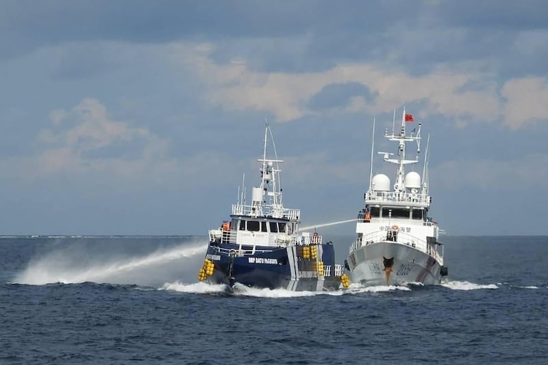 A China Coast Guard ship deploying water cannon next to a Philippine Bureau of Fisheries vessel near Thitu island in disputed waters of the South China Sea, Oct. 12, 2025.