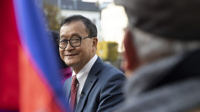 Cambodian opposition politician Sam Rainsy (C) speaks to a member of his delegation as he sits in front of the European Parliament in Brussels, Belgium, Nov. 4, 2019. Credit: AP Photo
