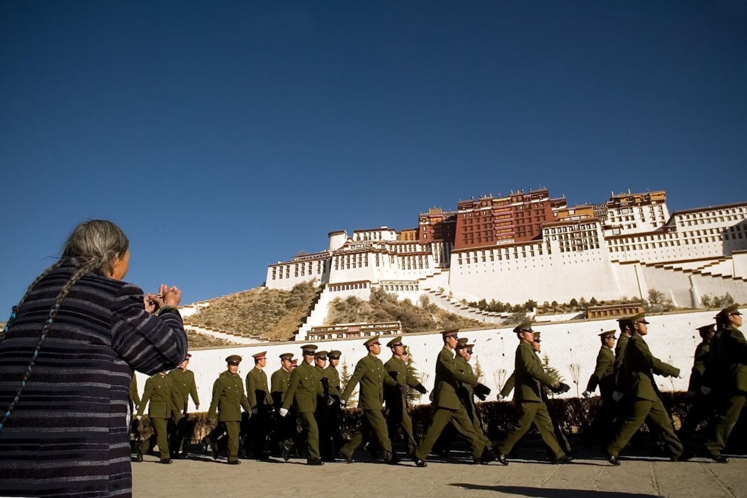 བོད་མི་ཞིག་གིས་ཕོ་བྲང་པོ་ཏཱ་ལའི་མདུན་དུ་སྨོན་ལམ་རྒྱག་བཞིན་པ།
