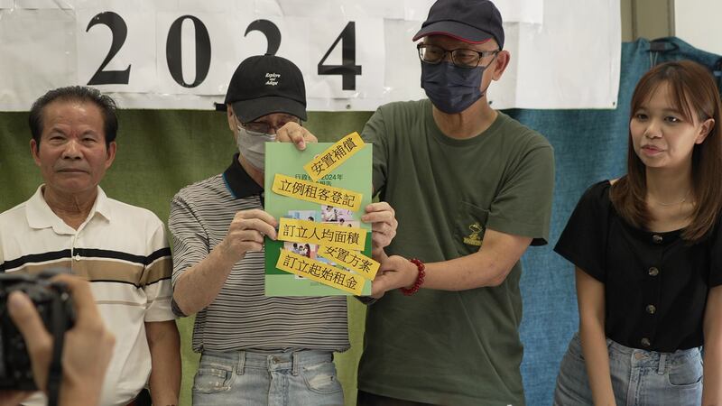 劏房戶在今年的《施政報告》封面上貼上他們的建議和訴求。(衛斯攝)