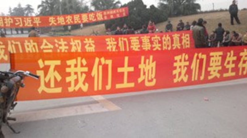 图片： 成都双流县近五百名失地村民拉横幅拦路抗议。 （村民提供/记者乔龙）