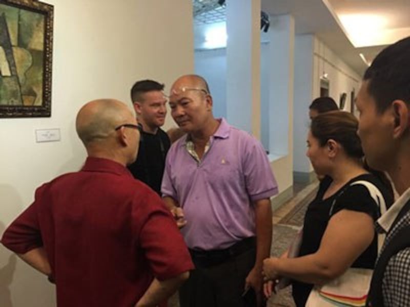 Nhà sưu tập Vũ Xuân Chung (áo tím) tranh cãi với họa sĩ Thành Chương (áo đỏ) về bức Trừu tượng, Tạ Tỵ, 1952. Ảnh chụp sáng 19/7/2016 tại Bảo tàng Mỹ thuật TPHCM. Photo courtesy of LĐ.