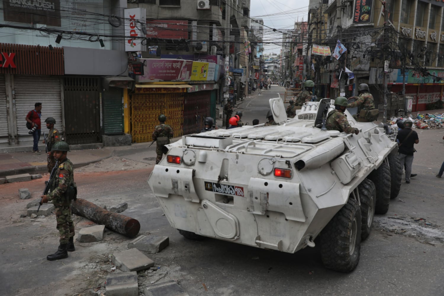 Military personnel take position around an armored vehicle in the Rampura area of Dhaka, July 20, 2024. (Jibon Ahmed/BenarNews)