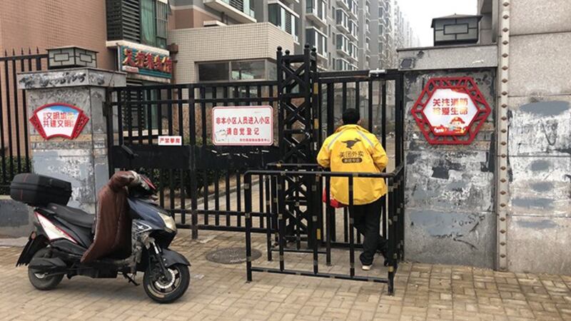 为避免新冠病毒感染，中国的许多居民小区对外关闭。图为北京一个小区外等待顾客接收定货的外卖。（Photo by Dylan Wang）