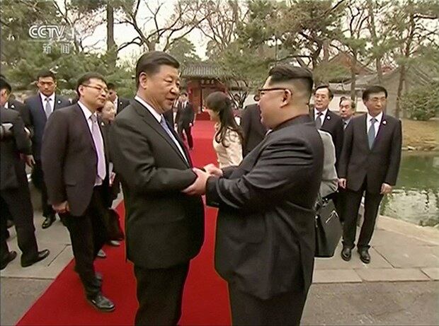 김정은 위원장(오른쪽)과 시진핑 주석이 악수를 하고 있다.