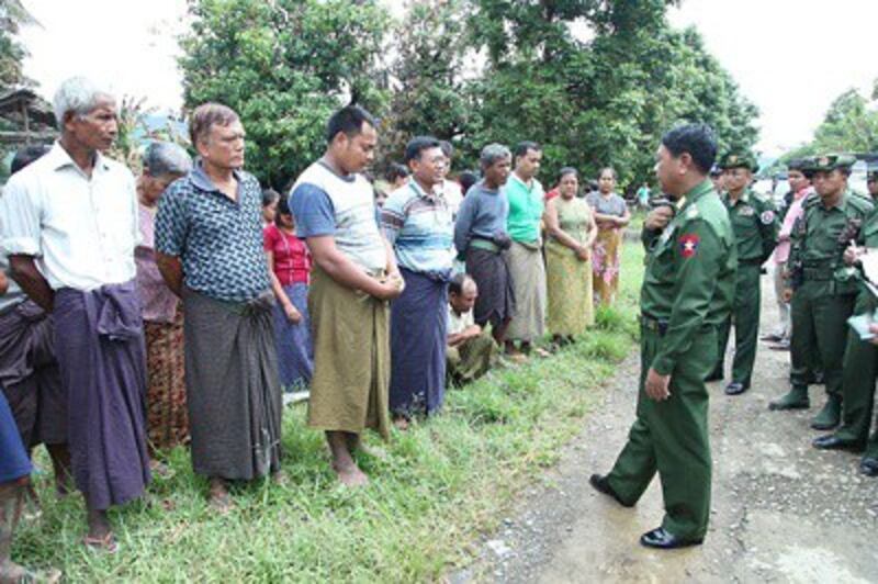 Myanmar's Minister of Defense Lieutenant General Hla Min (c) talks to Muslim residents who lost their homes at Pauktaw village in Thandwe, Oct. 3, 2013. Photo credit: RFA.