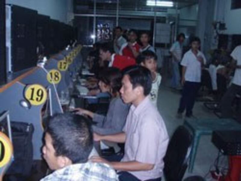 Hai nhân viên công ty phát hành game (áo đỏ) tiếp thị game online ngay tại tiệm internet. Photo courtesy tiemnet.vn