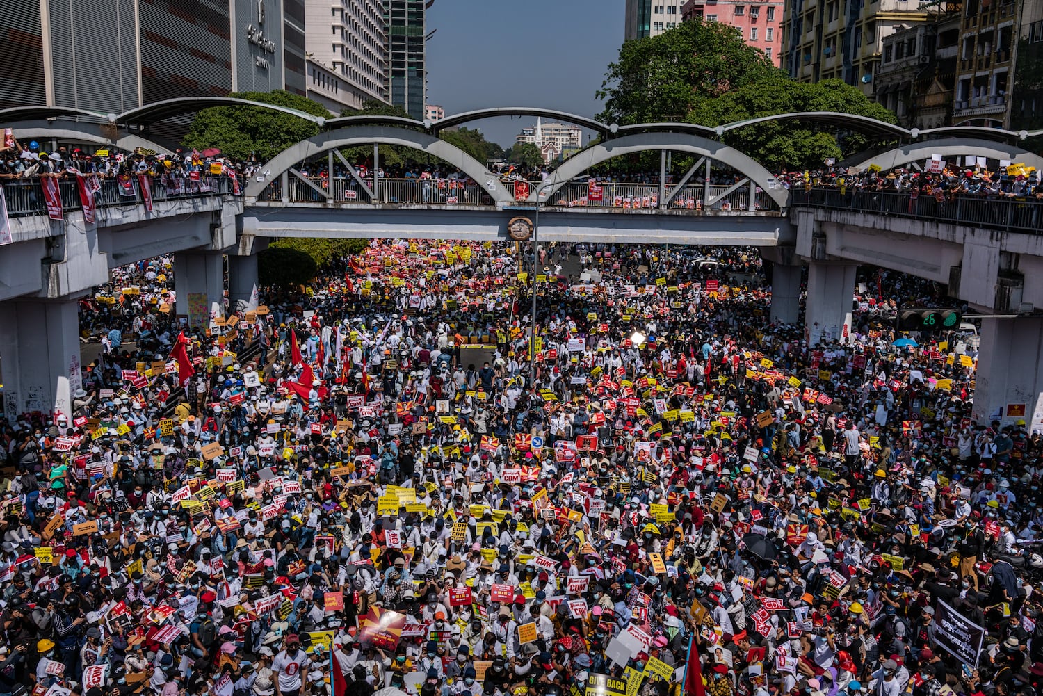 Protesters chant slogans and wave flags during an anti-coup protest at Sule Square on February 17, 2021 in Yangon, Myanmar.