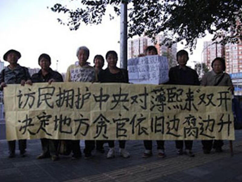 一批訪民9月底獲悉薄熙來被開除黨籍及公職後，拉起橫幅慶祝。（訪民提供）