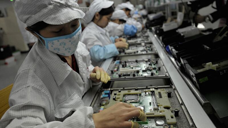 图为位于深圳的富士康工厂里的中国工人正在流水线上工作的场面。(法新社)